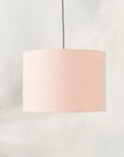Blush pink lampshade hanging from ceiling 