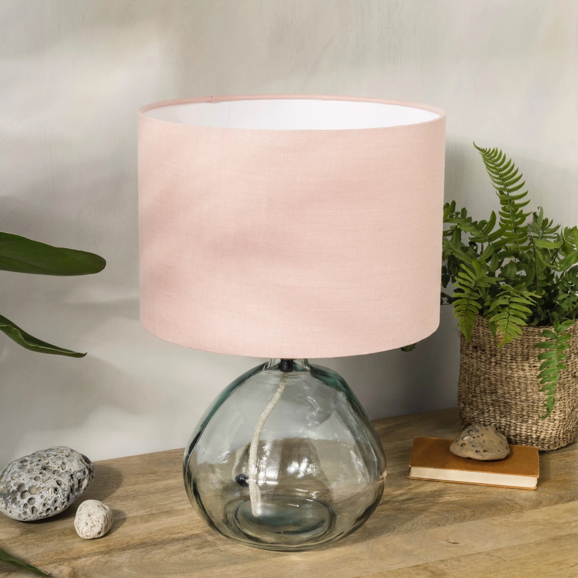 Blush pink lampshade on recycled glass base with baskets of plants