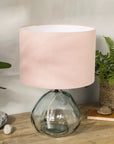 Blush pink lampshade on recycled glass base with baskets of plants